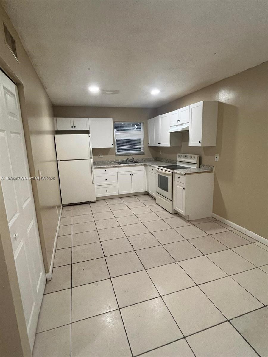 7490 Southwest 10th Court, Unit 14 North Lauderdale, FL 33068 - Photo 5 of 7 a kitchen with a stove a sink and a refrigerator