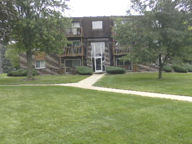 a view of a house with a big yard and large trees