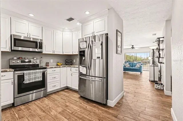 a kitchen with stainless steel appliances granite countertop a refrigerator microwave and stove top oven