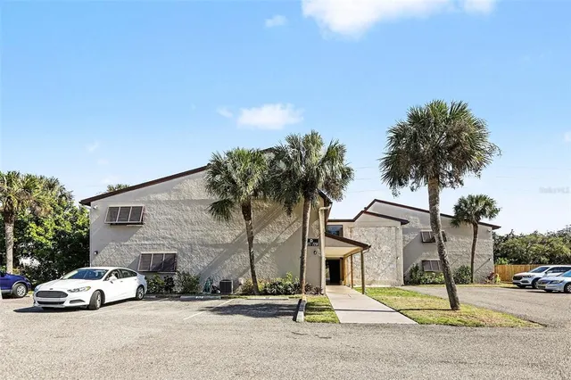 a building with trees and cars parked in front of it