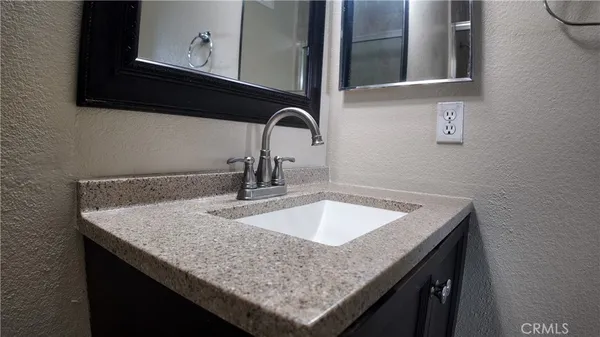 a bathroom with a sink a toilet a mirror and shower