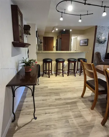 a living room with stainless steel appliances kitchen island granite countertop furniture and a wooden floor