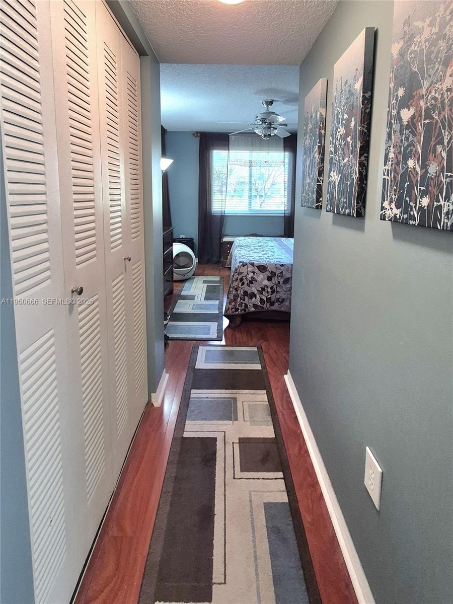 3854 Lyons Road, Unit 1025 Coconut Creek, FL 33073 - Photo 11 of 30 a view of a bedroom with wooden floor and furniture