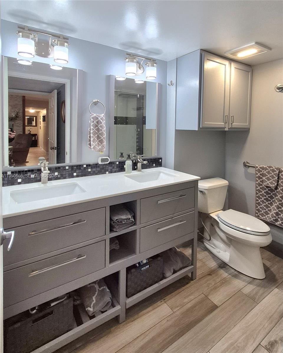 3854 Lyons Road, Unit 1025 Coconut Creek, FL 33073 - Photo 12 of 30 a bathroom with a toilet a sink and mirror