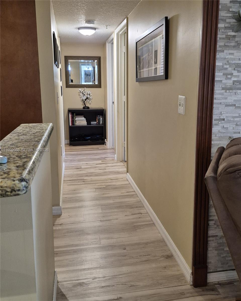 3854 Lyons Road, Unit 1025 Coconut Creek, FL 33073 - Photo 15 of 30 a view of a hallway with wooden floor and staircase