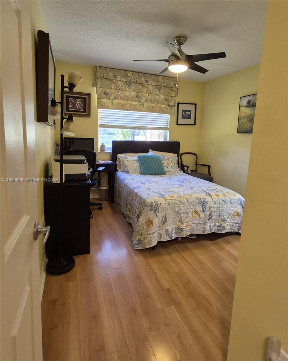 3854 Lyons Road, Unit 1025 Coconut Creek, FL 33073 - Photo 17 of 30 a bedroom with a bed and ceiling fan