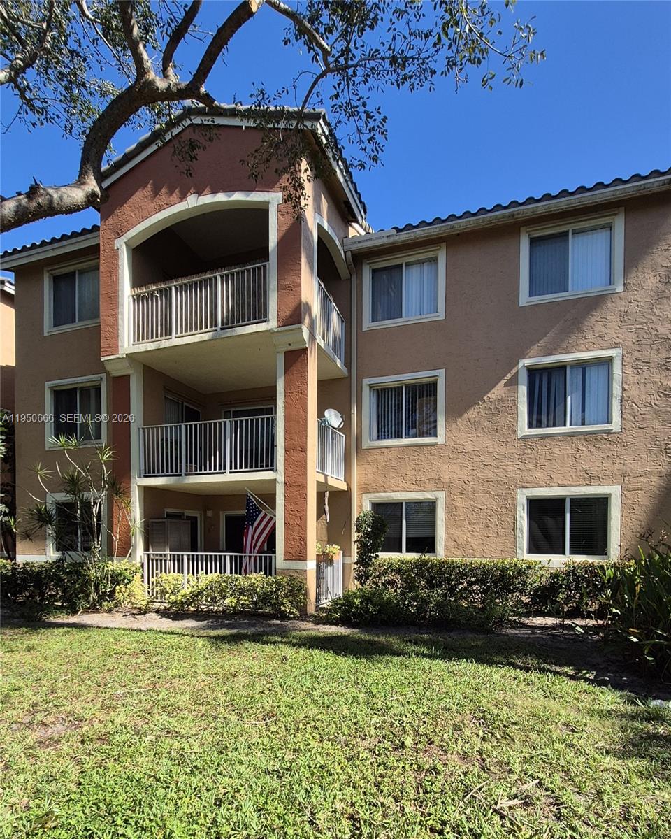 3854 Lyons Road, Unit 1025 Coconut Creek, FL 33073 - Photo 22 of 30 a front view of a residential apartment building with a yard