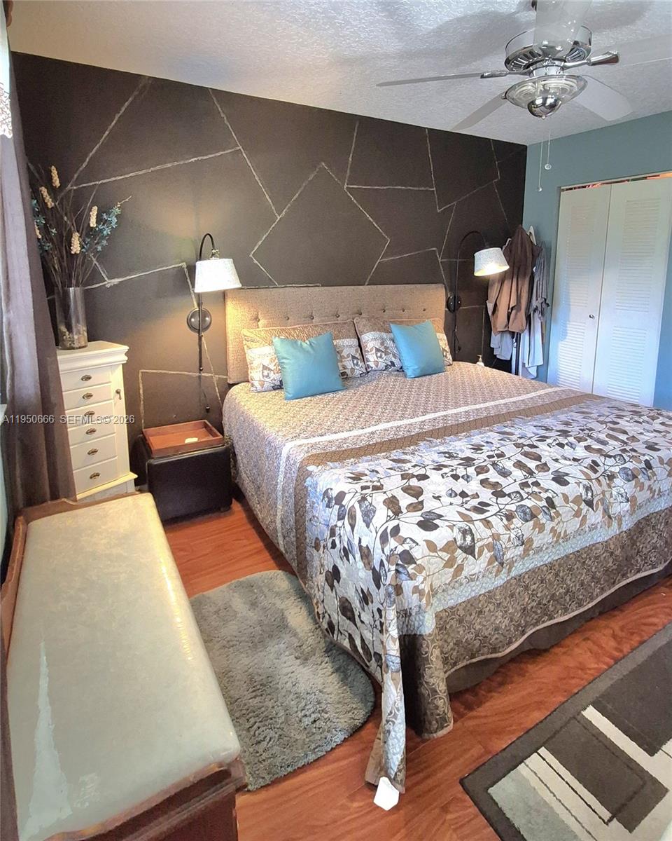 3854 Lyons Road, Unit 1025 Coconut Creek, FL 33073 - Photo 8 of 30 a bedroom with a bed and a mirror