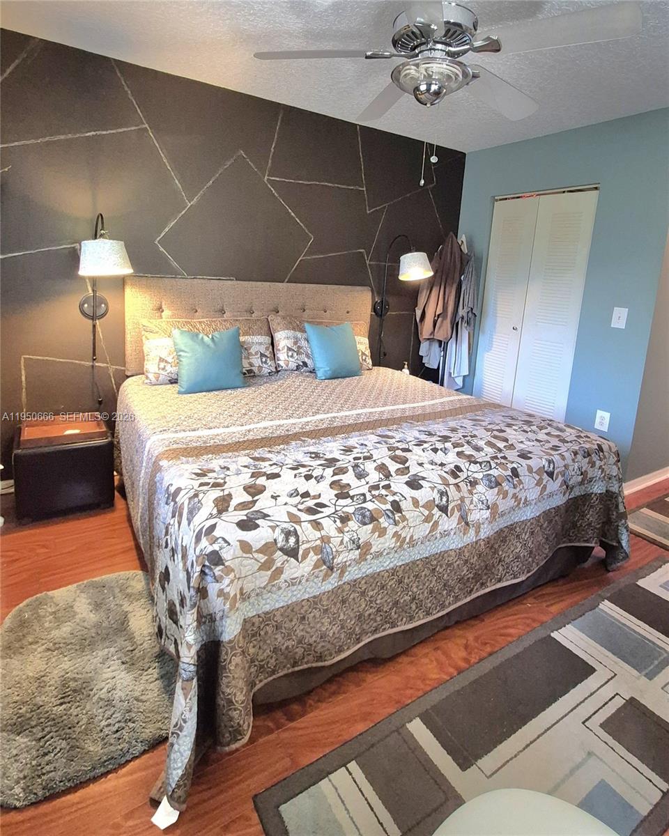 3854 Lyons Road, Unit 1025 Coconut Creek, FL 33073 - Photo 10 of 30 a bed sitting in a bedroom and lamp