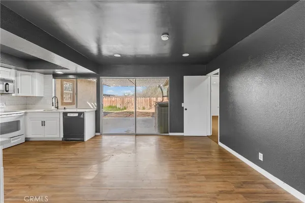 a view of a kitchen with stainless steel appliances granite countertop a stove and a refrigerator