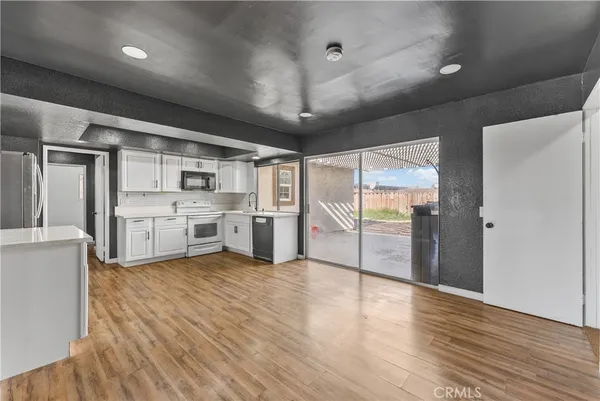 a kitchen with stainless steel appliances kitchen island granite countertop a sink cabinets and wooden floor