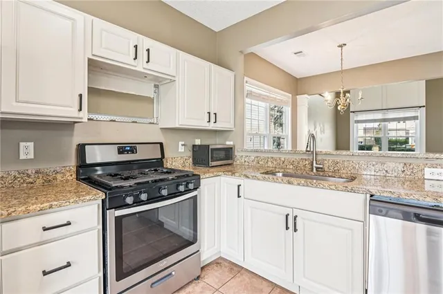 a kitchen with granite countertop white cabinets and appliances