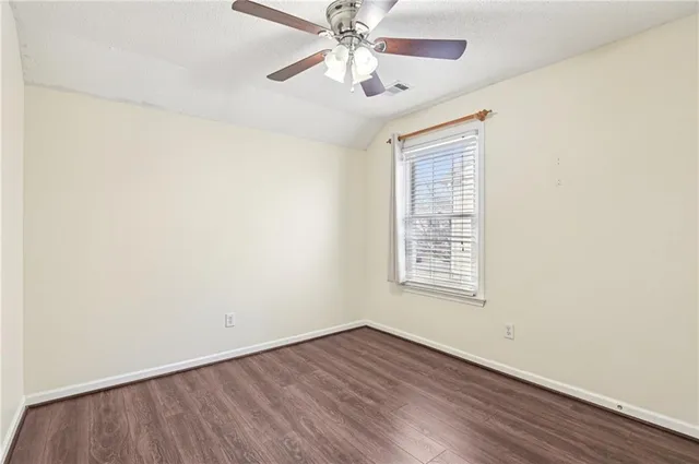 an empty room with a window and a ceiling fan