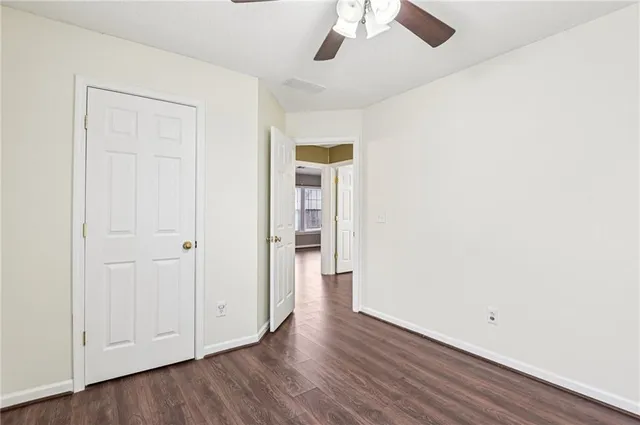 an empty room with a hardwood and ceiling fan