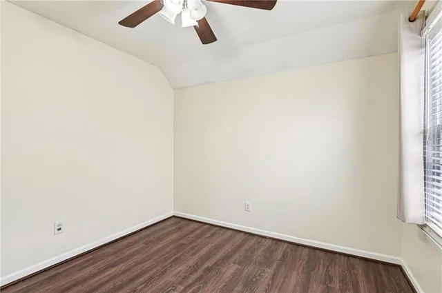 a view of a small space with wooden floor and a window