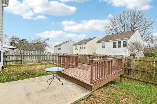 a view of a roof deck with couches and a table and chairs with wooden floor