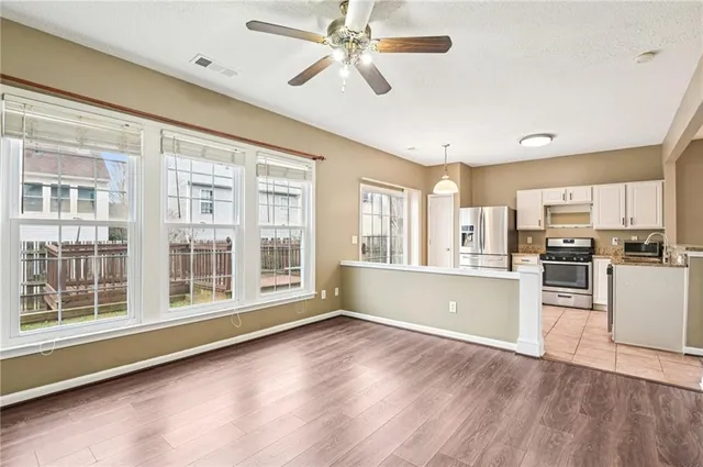 a view of a kitchen with refrigerator and wooden floor
