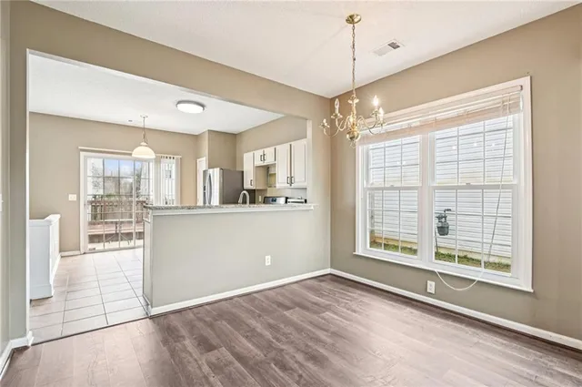 a view of a kitchen with wooden floor and a window