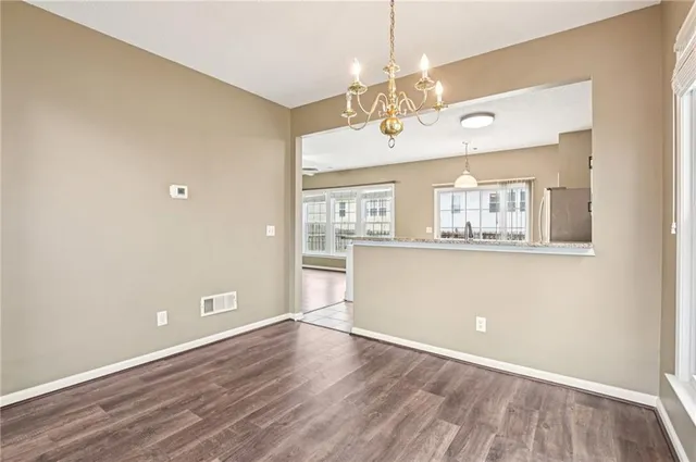 a view of a room with wooden floor and kitchen view