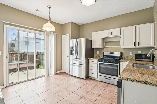 a kitchen with stainless steel appliances granite countertop a refrigerator a stove a sink and a granite counter tops