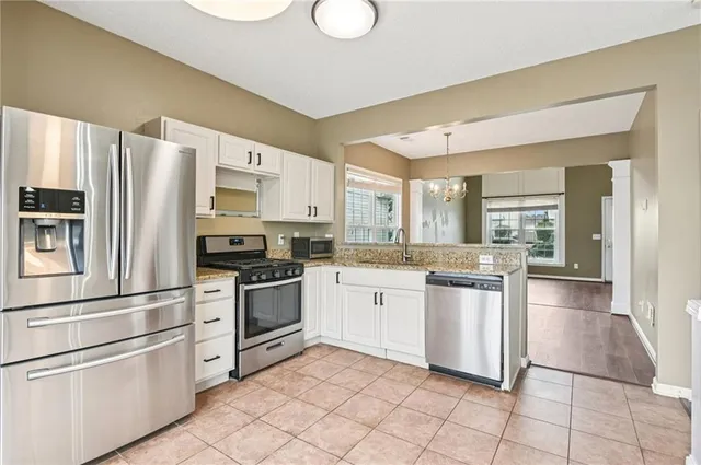 a kitchen with stainless steel appliances granite countertop a refrigerator sink and stove