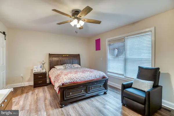 a bedroom with a bed couch and a view of kitchen