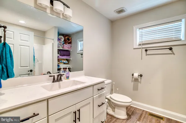 a bathroom with a sink a toilet and a mirror