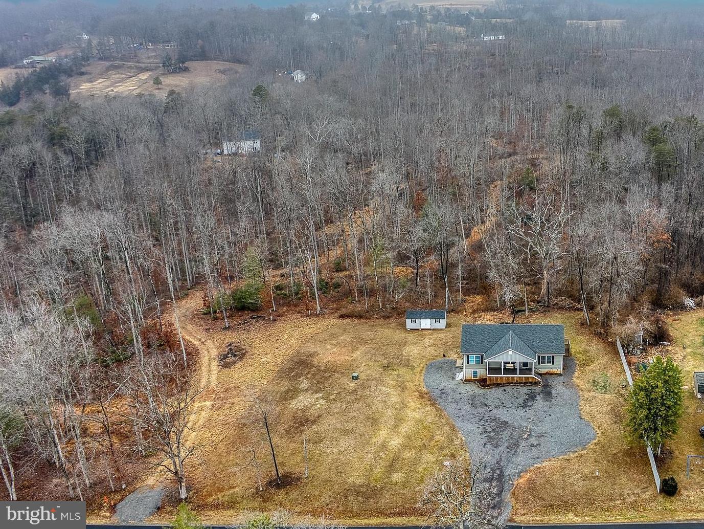 13084 Stonehouse Mountain Road Culpeper, VA 22701 - Photo 32 of 37 a backyard of a house with table and chairs