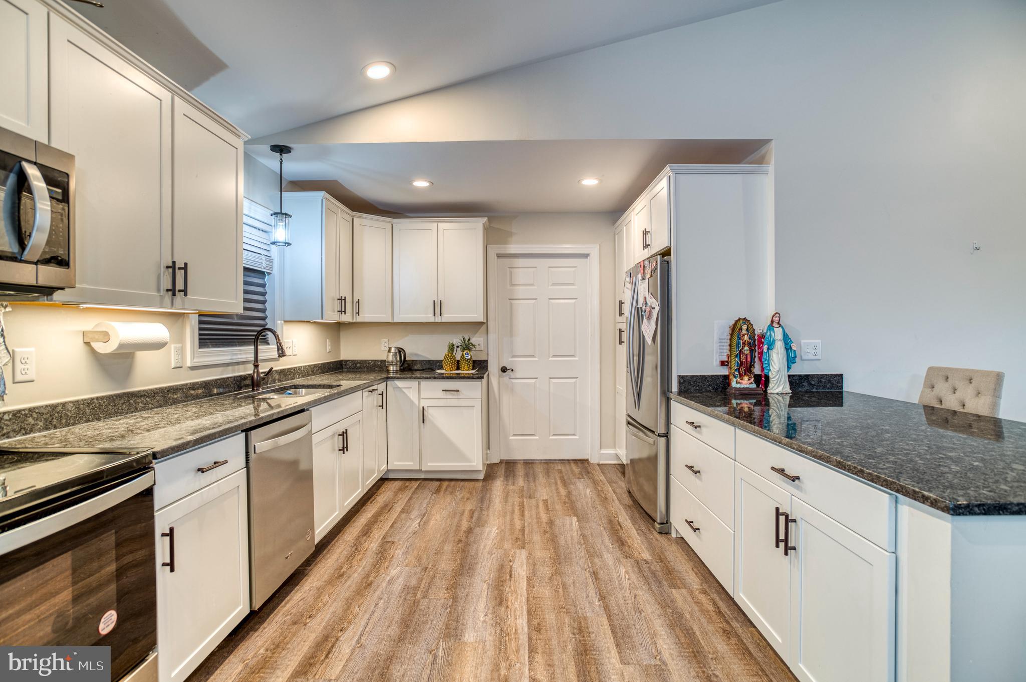 13084 Stonehouse Mountain Road Culpeper, VA 22701 - Photo 5 of 37 a large kitchen with stainless steel appliances granite countertop a lot of counter space and wooden floors
