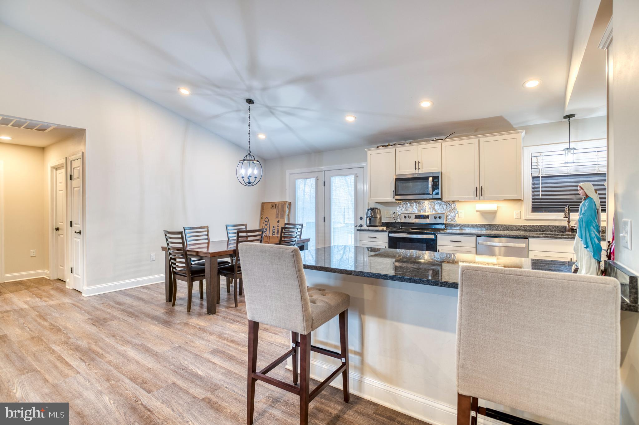 13084 Stonehouse Mountain Road Culpeper, VA 22701 - Photo 8 of 37 a kitchen view with stainless steel appliances granite countertop a stove a refrigerator a kitchen island a table and chairs with wooden floor