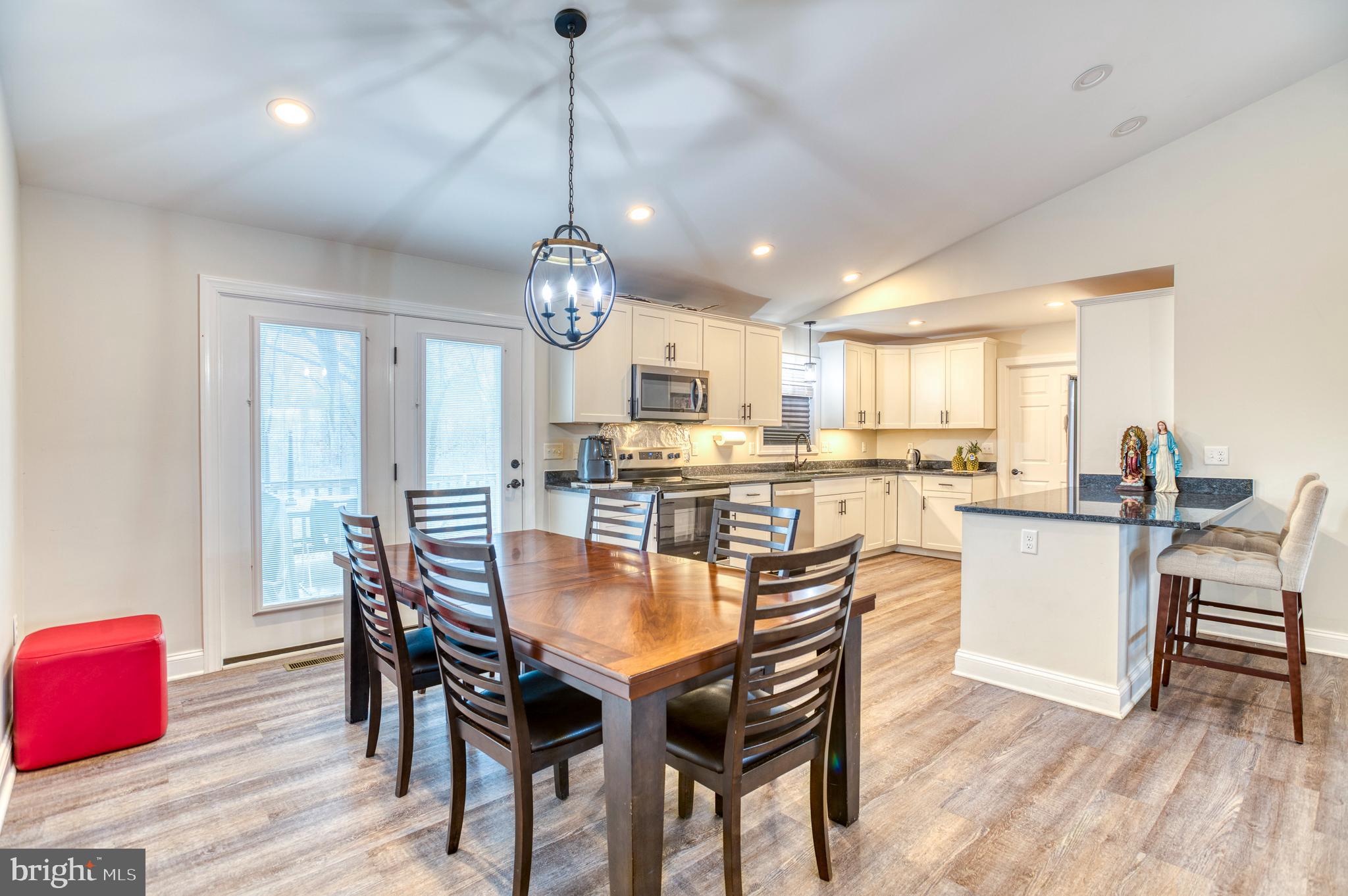 13084 Stonehouse Mountain Road Culpeper, VA 22701 - Photo 10 of 37 a dining room with wooden floor a chandelier a wooden table and chairs
