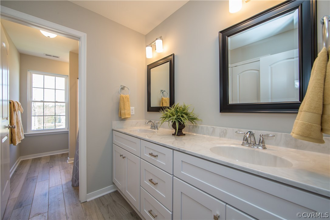 8955 Lavenham Loop Midlothian, VA 23112 - Photo 39 of 47 a bathroom with a double vanity sink and mirror