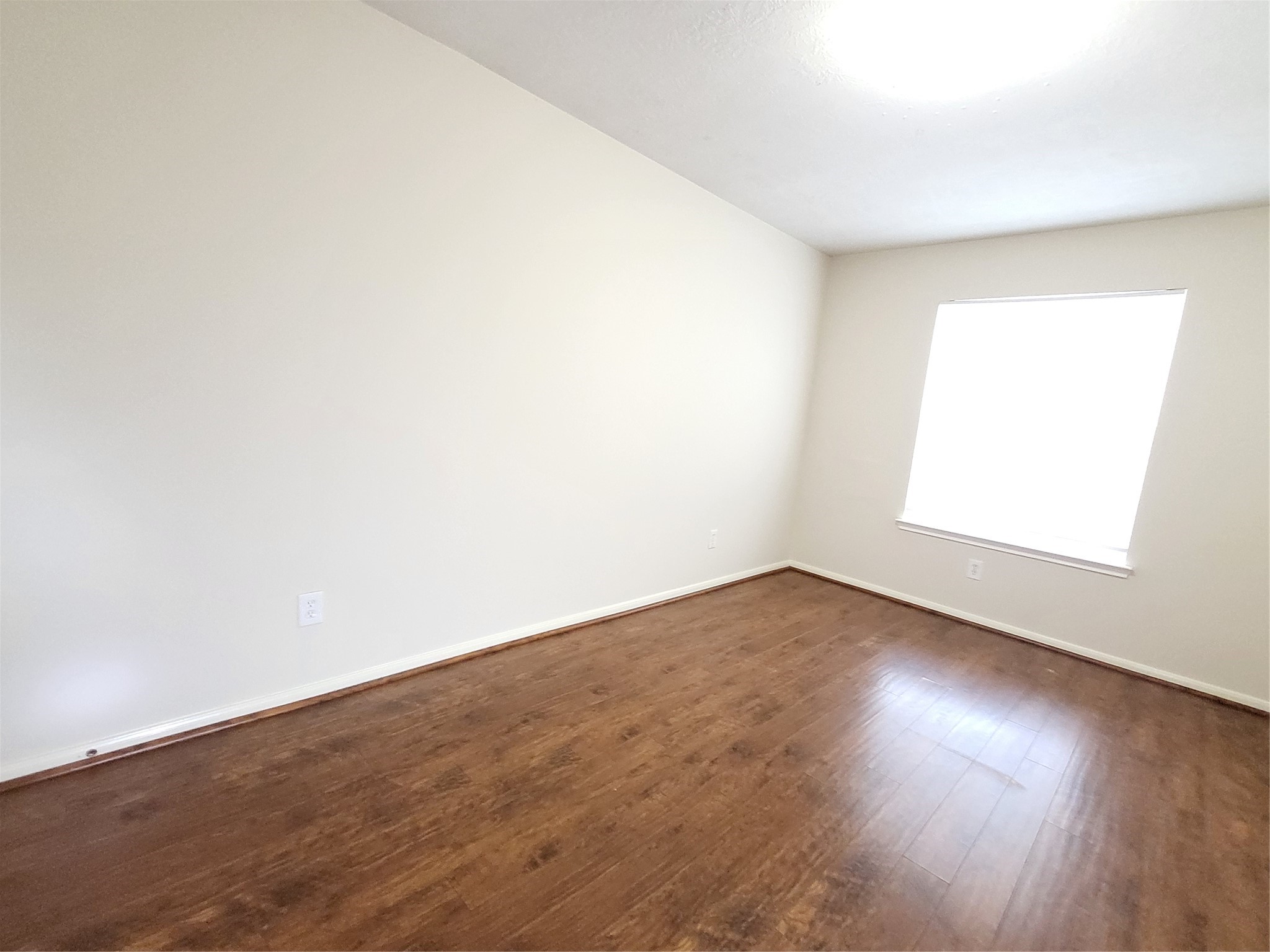 14034 Maximos Drive Houston, TX 77083 - Photo 20 of 27 an empty room with wooden floor and windows