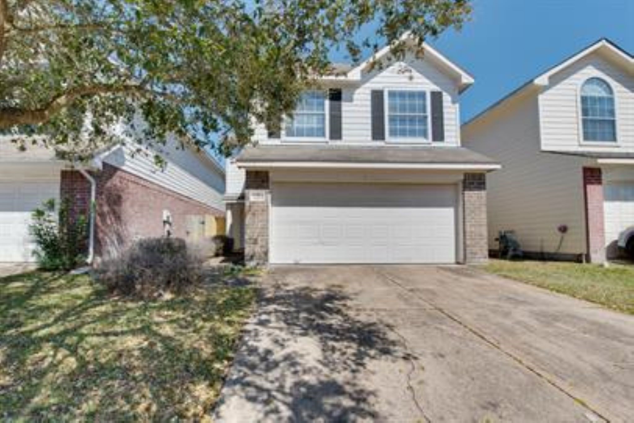 14034 Maximos Drive Houston, TX 77083 - Photo 2 of 27 a front view of a house with a yard and garage
