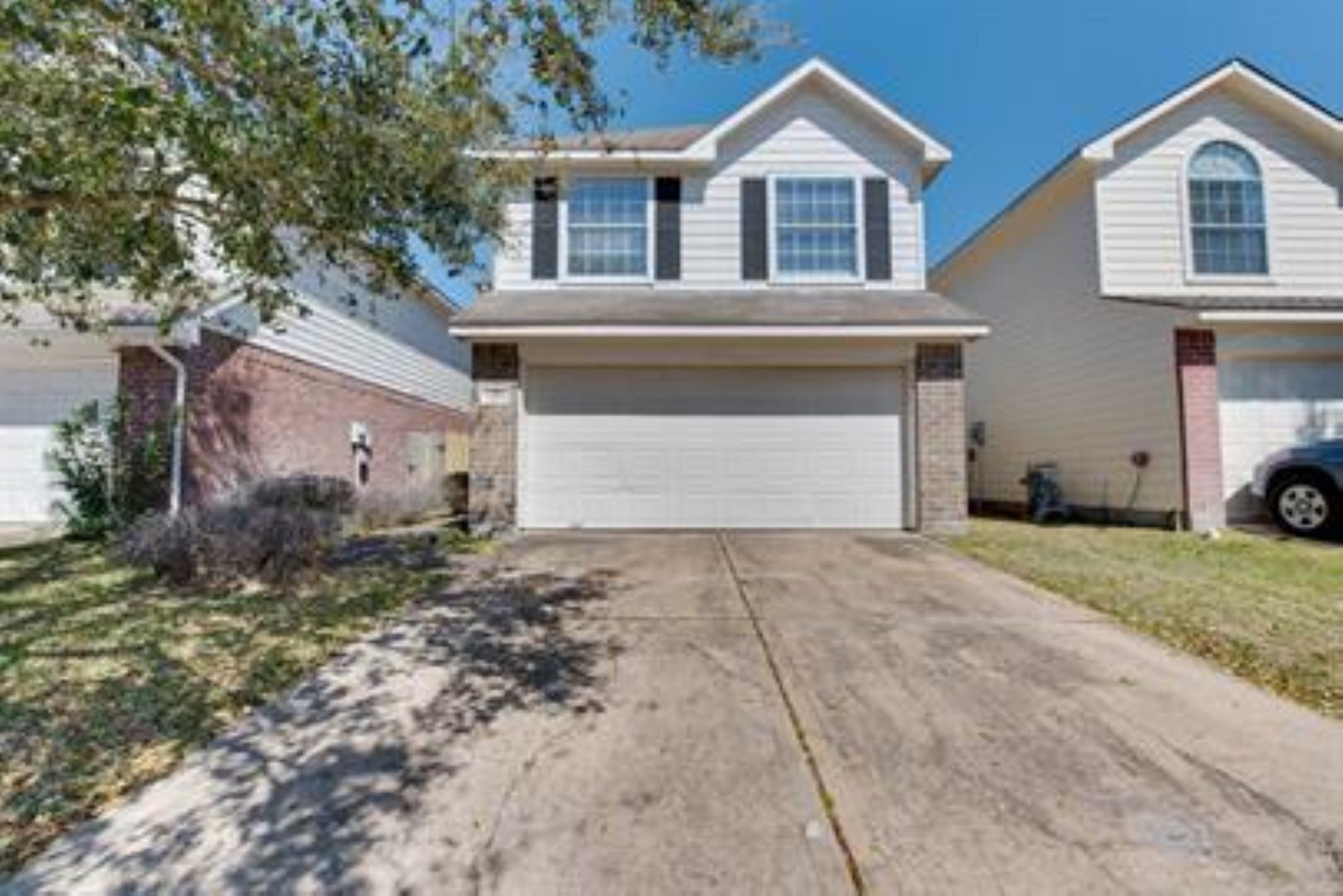 14034 Maximos Drive Houston, TX 77083 - Photo 3 of 27 a front view of a house with a yard and garage