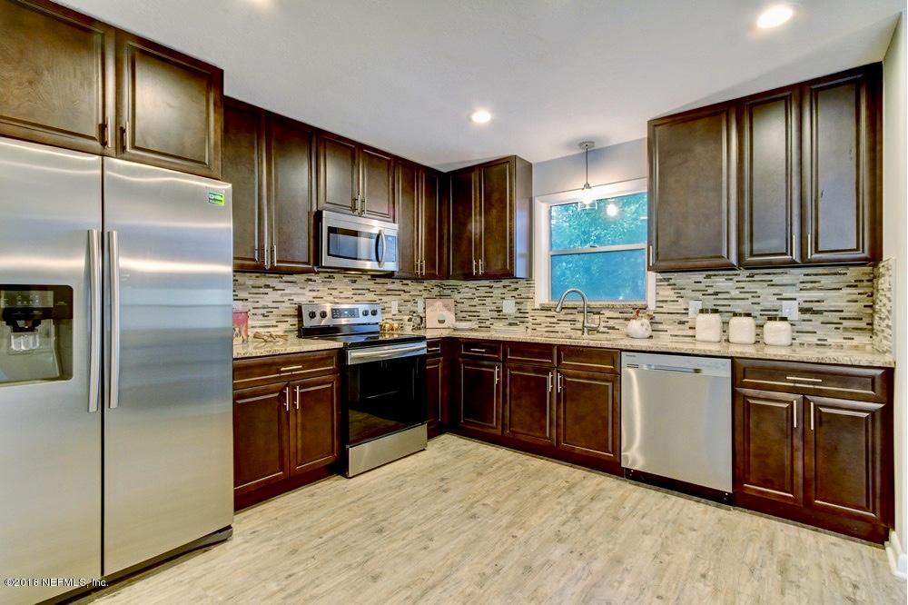 6815 Heidi Road Jacksonville, FL 32277 - Photo 12 of 36 a kitchen with stainless steel appliances granite countertop wooden cabinets a refrigerator a stove a sink and dishwasher