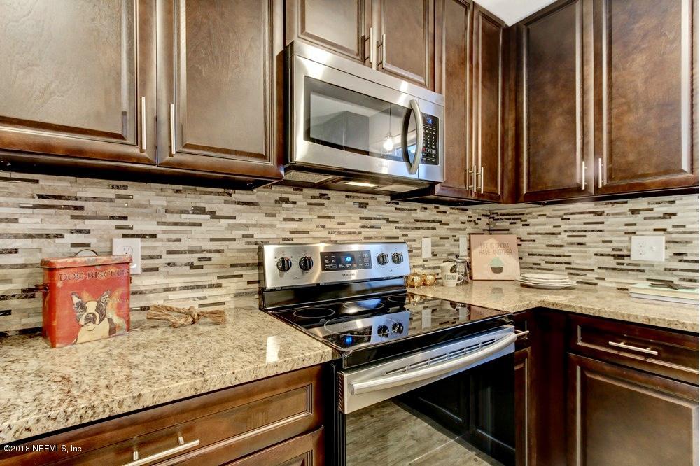 6815 Heidi Road Jacksonville, FL 32277 - Photo 14 of 36 a kitchen with stainless steel appliances granite countertop a sink stove and microwave