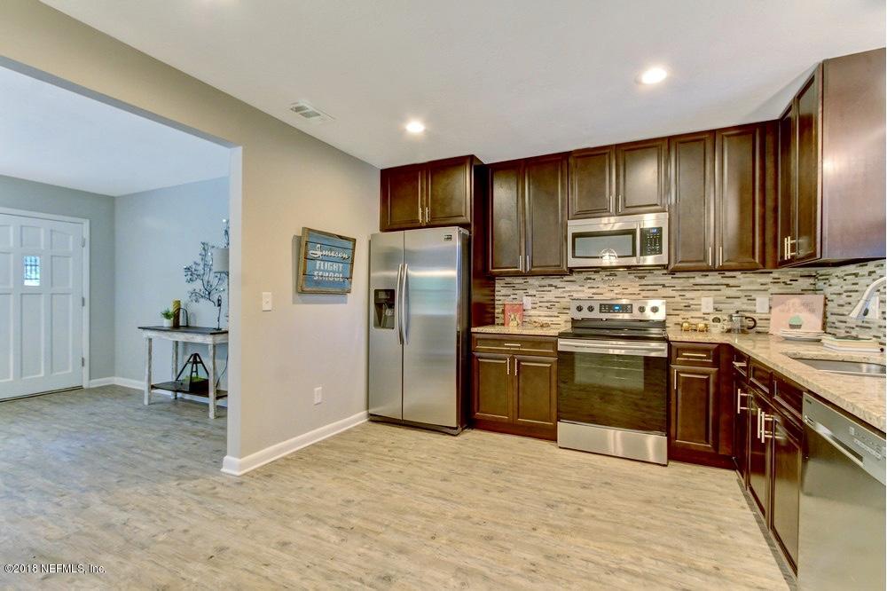 6815 Heidi Road Jacksonville, FL 32277 - Photo 15 of 36 a kitchen with stainless steel appliances granite countertop a refrigerator stove and sink