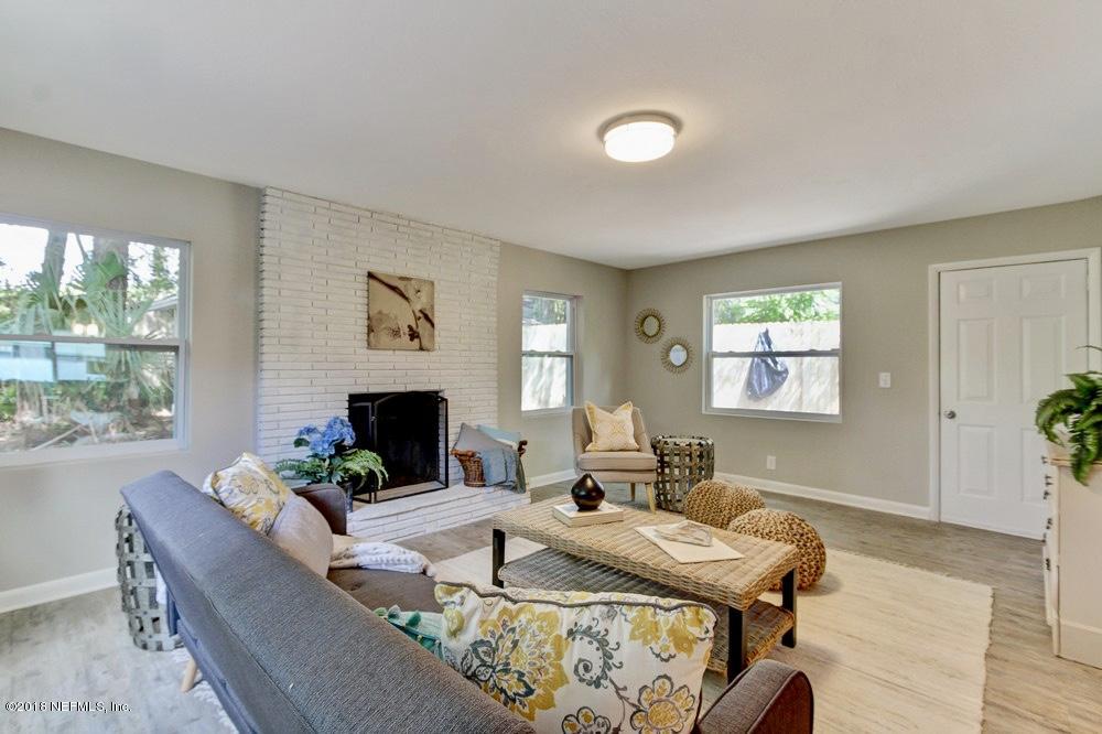 6815 Heidi Road Jacksonville, FL 32277 - Photo 17 of 36 a living room with furniture a flat screen tv and a fireplace