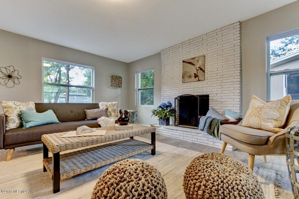 6815 Heidi Road Jacksonville, FL 32277 - Photo 19 of 36 a living room with furniture a rug and a fireplace