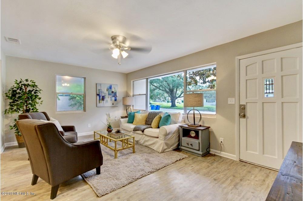 6815 Heidi Road Jacksonville, FL 32277 - Photo 2 of 36 a living room with furniture a chandelier and a window