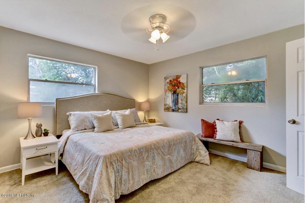 6815 Heidi Road Jacksonville, FL 32277 - Photo 21 of 36 a bedroom with a bed and a chandelier