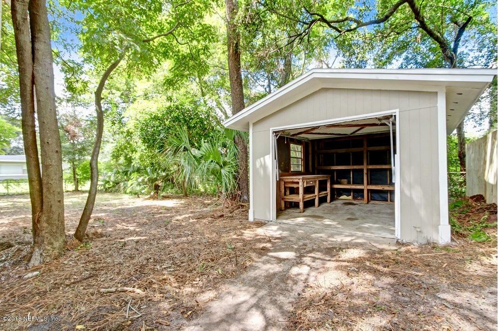 6815 Heidi Road Jacksonville, FL 32277 - Photo 31 of 36 a view of a house with a large tree and wooden fence
