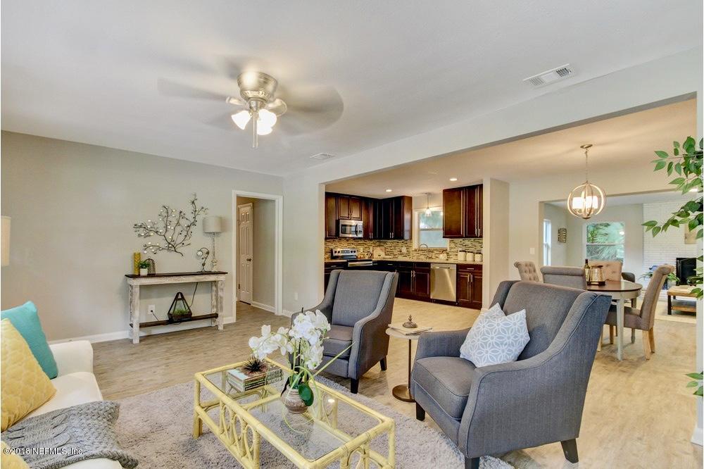 6815 Heidi Road Jacksonville, FL 32277 - Photo 5 of 36 a living room with furniture a fireplace and a flat screen tv