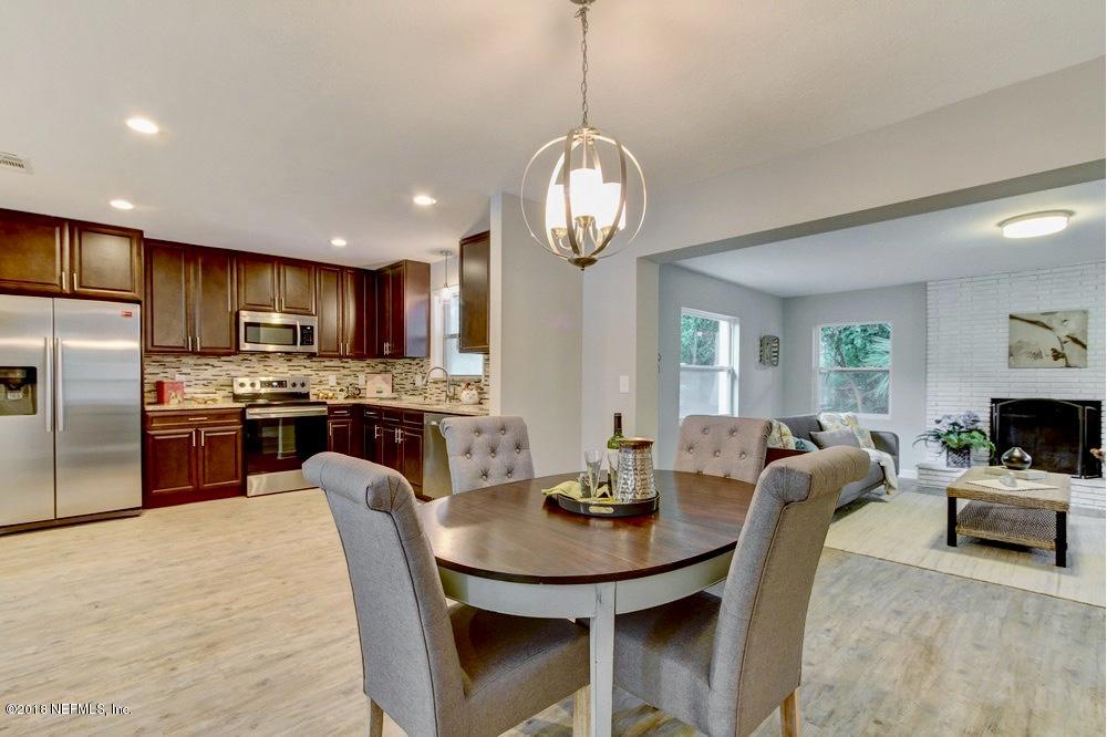 6815 Heidi Road Jacksonville, FL 32277 - Photo 9 of 36 a kitchen with stainless steel appliances a dining table and chairs