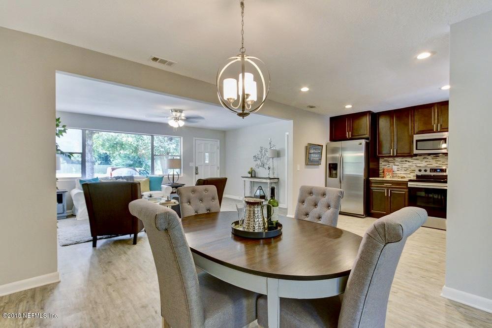 6815 Heidi Road Jacksonville, FL 32277 - Photo 10 of 36 a view of a dining room with furniture a chandelier and wooden floor