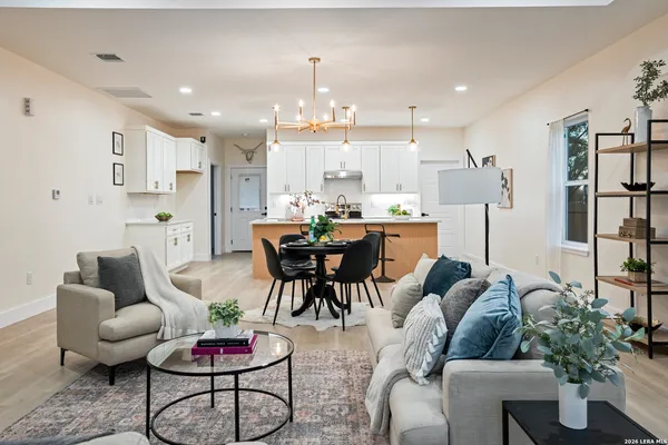 a living room with furniture kitchen and a potted plant