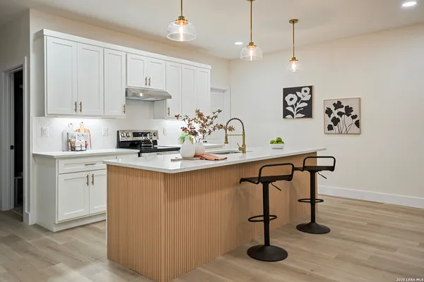 a kitchen with stainless steel appliances granite countertop a sink a stove and a refrigerator