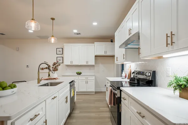 a kitchen with a sink a stove and cabinets
