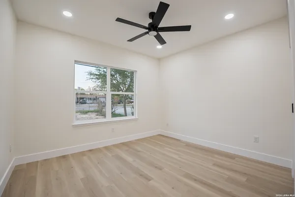 an empty room with a window and a fan
